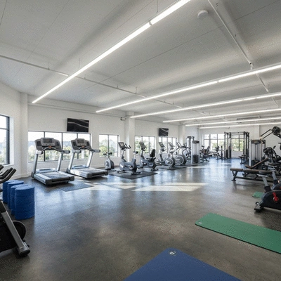 Modern gym interior with various fitness equipment and bright lighting